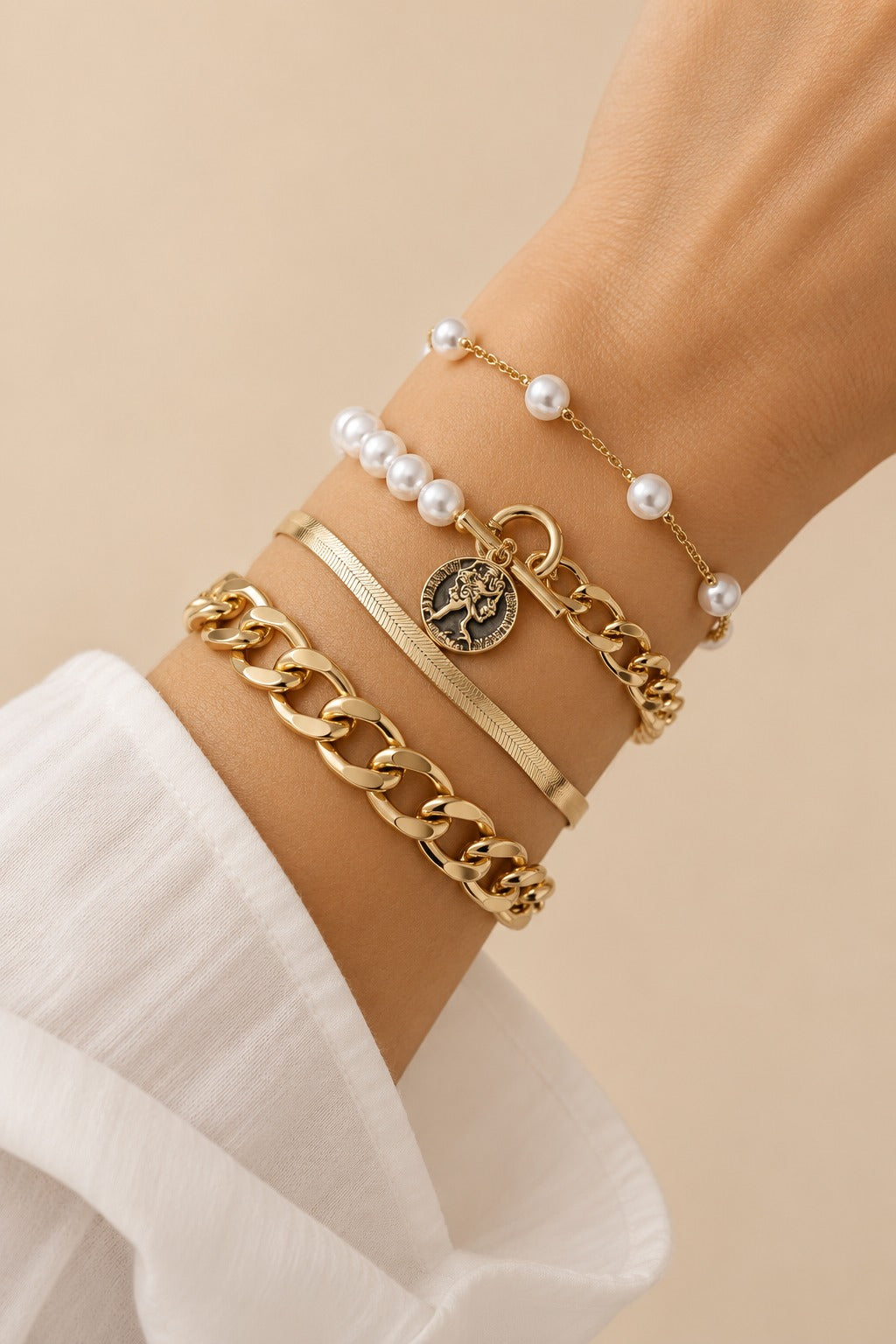 Gold-tone pearl bracelet set worn naturally on the wrist.