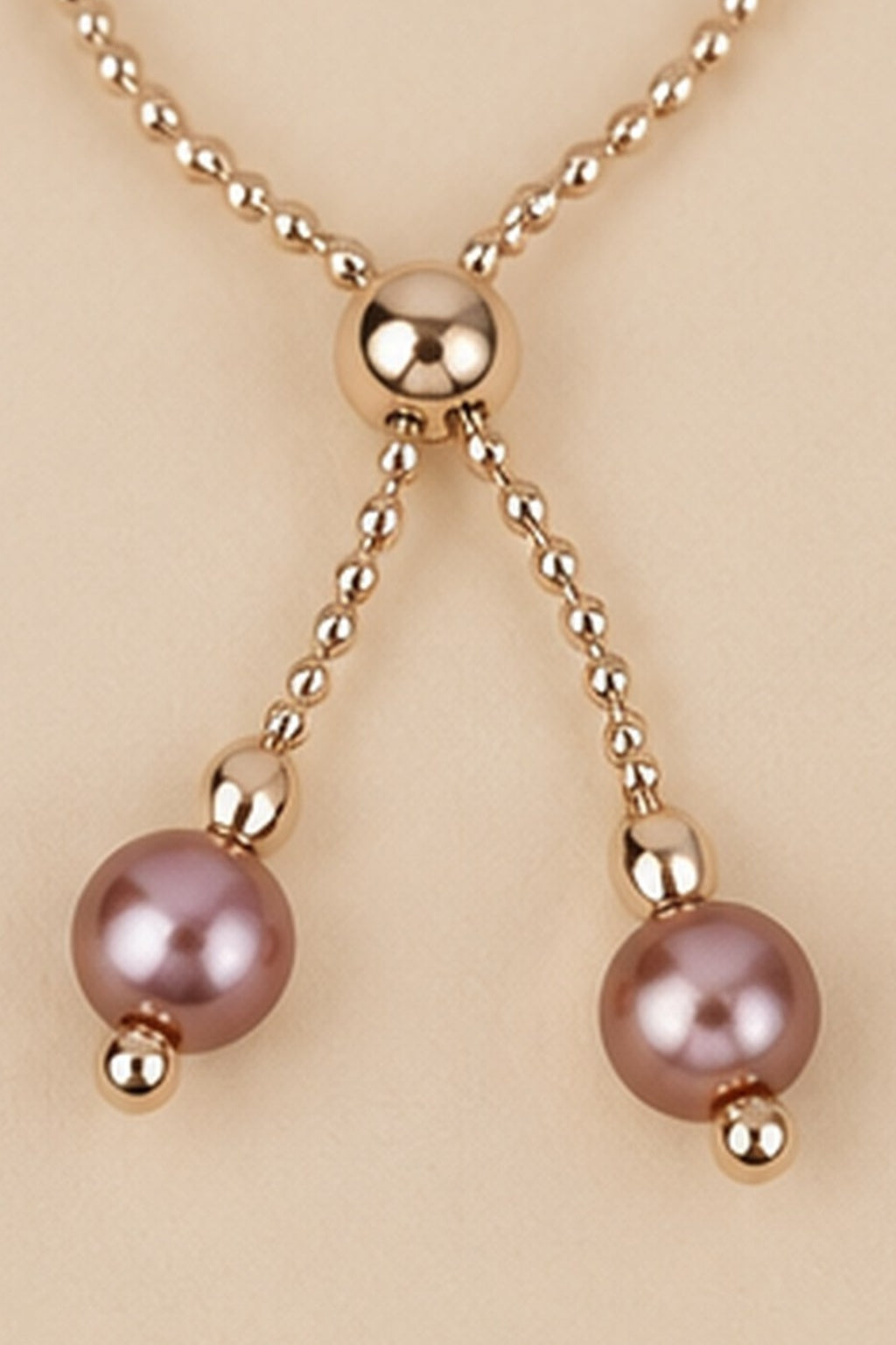 Detail of the adjustable slider and dangling mauve pink beads on the Pearl Slider Bracelet.