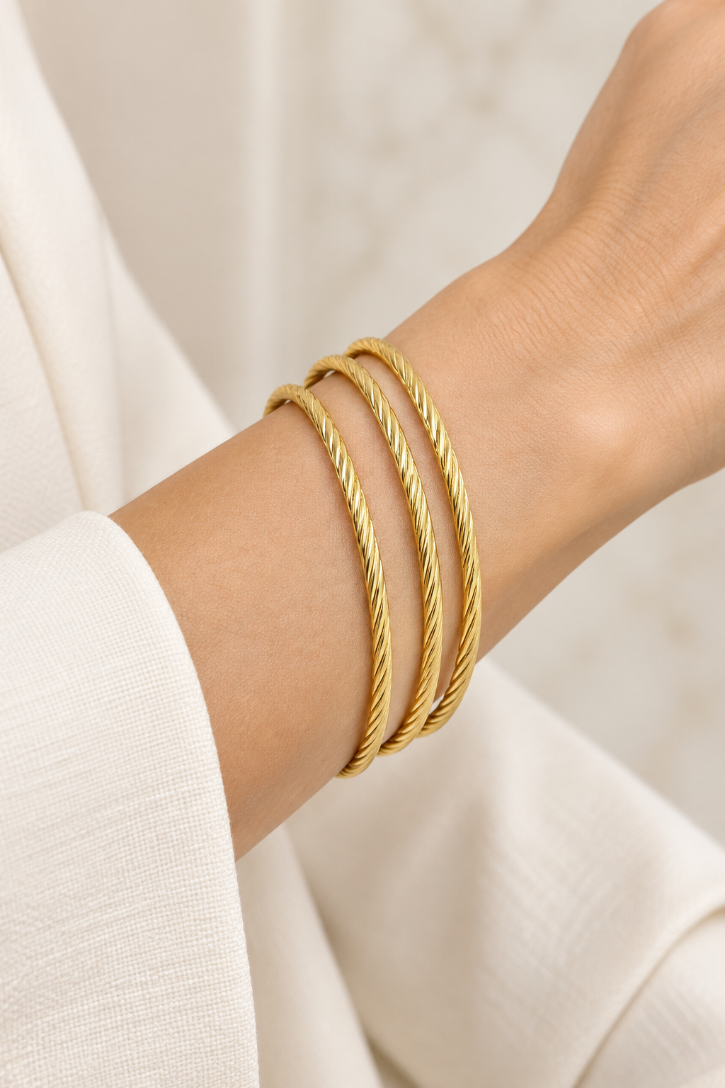 Style 002 three-ring gold-tone bangle set worn on wrist