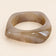 Coffee-tone geometric resin bangle on a plain beige background.