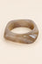 Coffee-tone geometric resin bangle on a plain beige background.