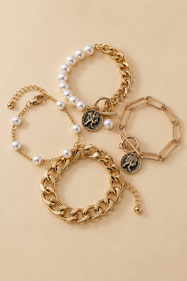 Gold-tone pearl bracelet set arranged in a natural layered flat lay on a warm beige background.