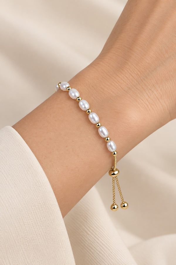 Gold-tone pearl slider bracelet worn naturally on the wrist.