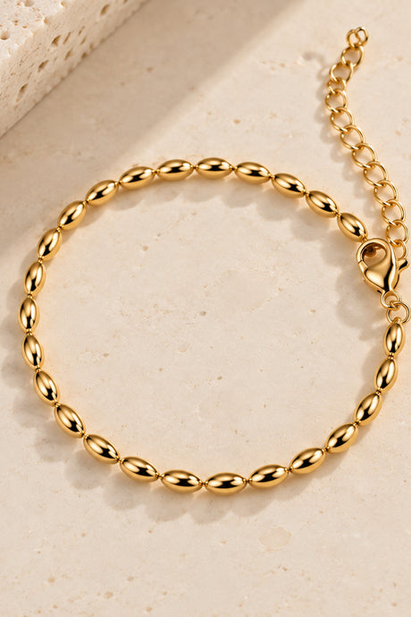 Close-up alternate view of gold-tone oval beads, clasp and extender chain.