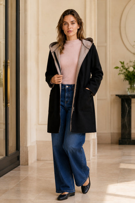 Manteau noir à capuchon Holly porté à l’intérieur avec jean foncé à jambe large