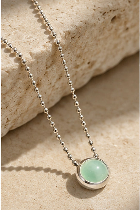 Détail du pendentif cabochon vert menthe et de la chaîne argentée