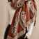 Rust-brown paisley fringe scarf worn by an ONZE model