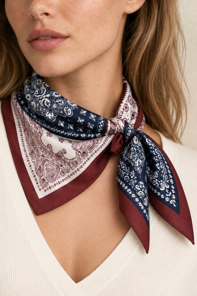 Model wearing a patchwork paisley square scarf in navy, ivory and burgundy