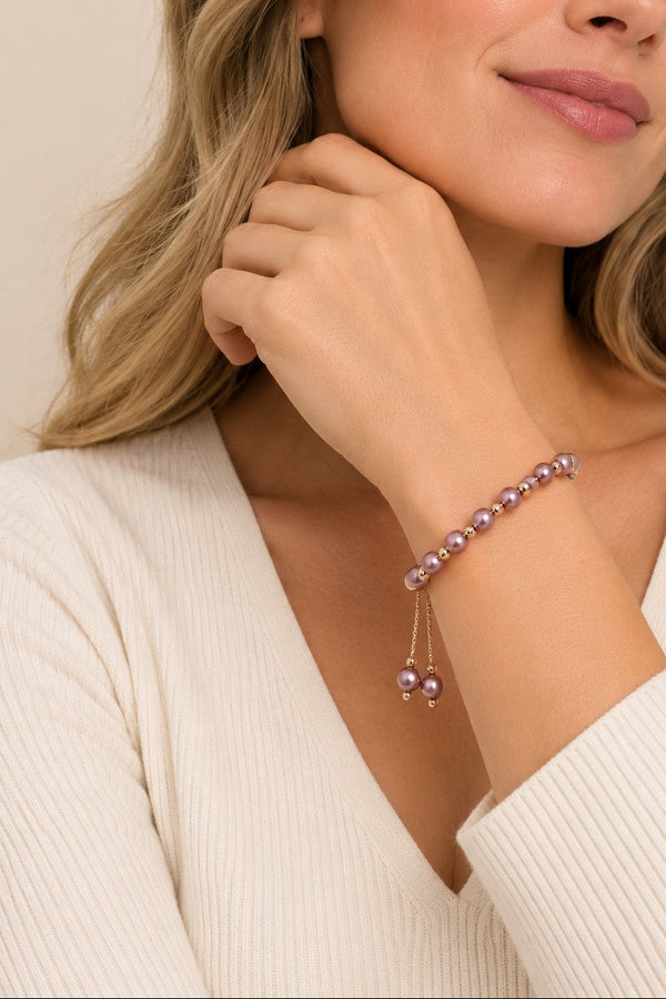 Mauve pink imitation-pearl slider bracelet worn individually on the wrist.