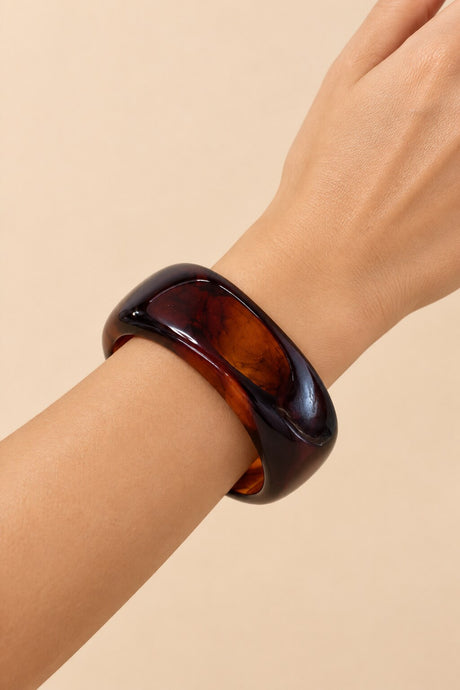Red amber geometric bangle worn on the wrist.