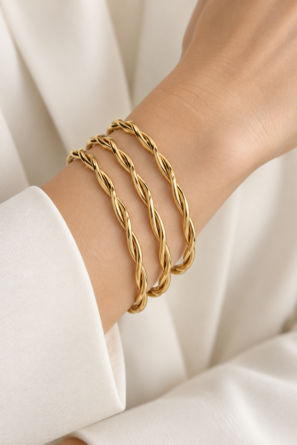 Style 008 three-ring twisted gold-tone bangle set worn on wrist
