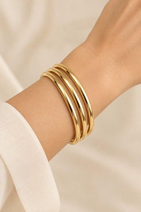 Three-ring gold-tone bangle set worn on wrist