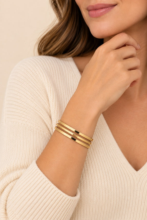 Gold-tone three-ring bangle set worn on the wrist.