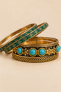 Turquoise-tone and gold-tone vintage-inspired bangle set shown in a detailed alternate arrangement on a beige background.
